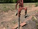 Red spigot hardware in rose garden.