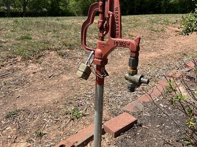 Red spigot hardware in rose garden.