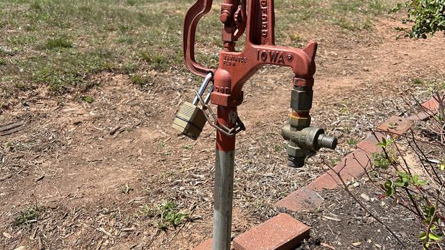 Red spigot hardware in rose garden.