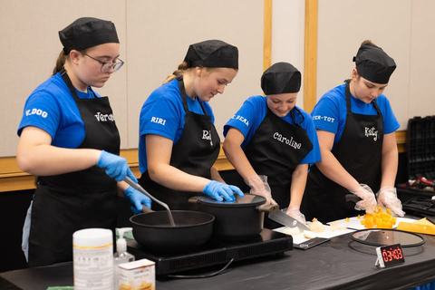 Four youths are cooking at a competition