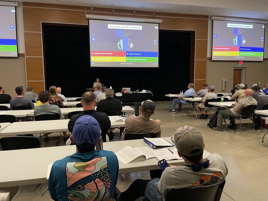 A classroom of adult students at the Pesticide Safety School playing a review game using their smartphones.