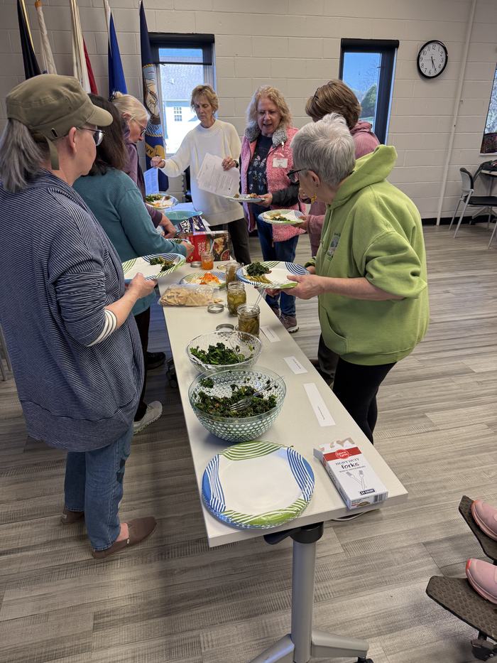 Seed to Supper participants gathered around a table sampling vegetable dishes during a class activity focused on preparing and using fresh garden produce.