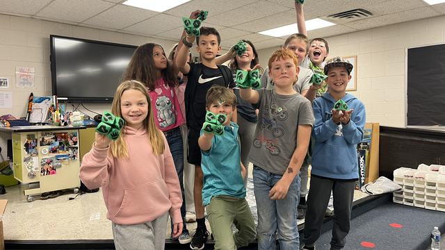 4-H club members posing with a clover catcher craft