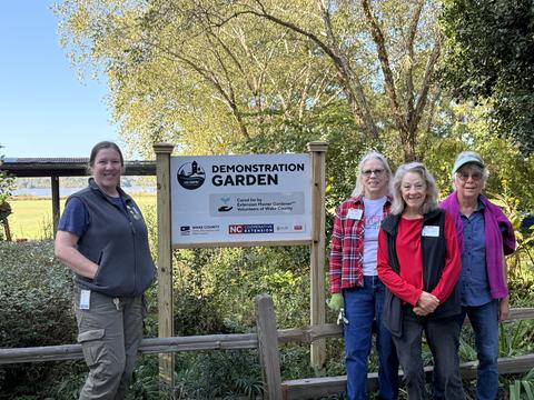 Lake Crabtree Team standing with the new garden sign, Fall 2025