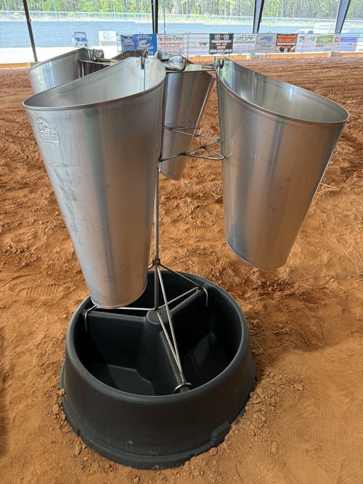 A high-angle shot of a poultry kill station with multiple stainless steel restraining cones mounted on a metal stand above a black plastic base