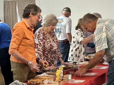Servers fill up the plates at the Wild Foods Cook Off