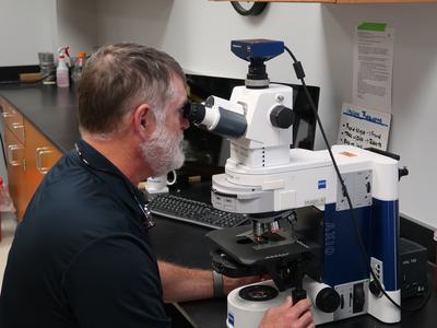 A man looking through a microscope.