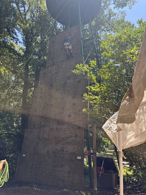 4-H camper climbing a rock wall at camp.
