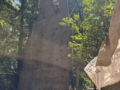 4-H camper climbing a rock wall at camp.