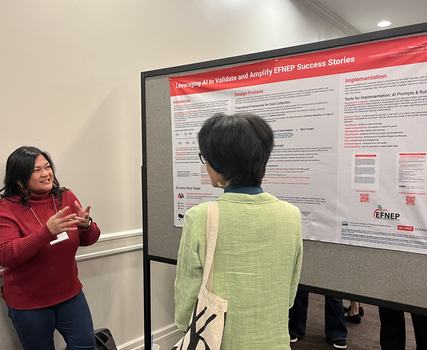 Lisa Benavente talking with conference attendee at poster session