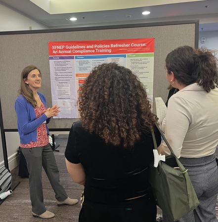 Megan Berthiaume talking with conference attendees at poster session