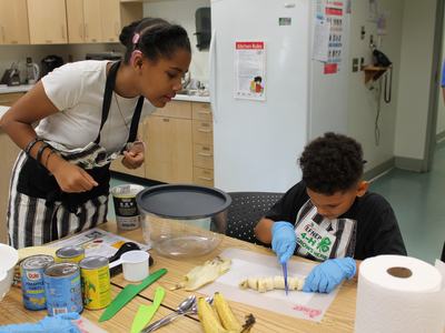 Campers are cutting up bananas for a smoothie.