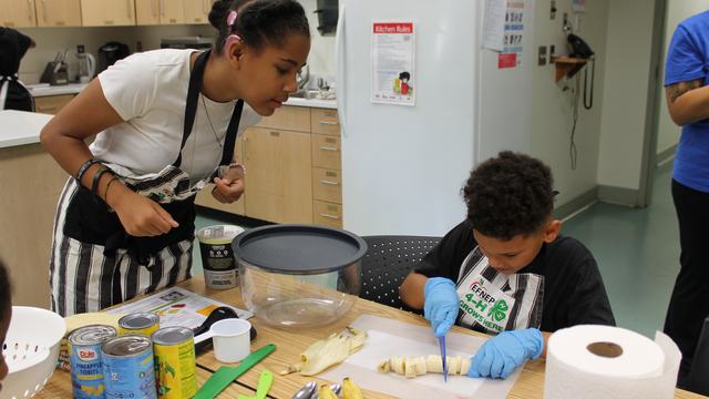 Campers are cutting up bananas for a smoothie.