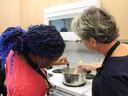 EFNEP educator and camper are testing the temperature of the meat in pot.