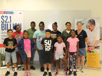 Randolph House students stand at graduation with EFNEP Agent Angie Lawrence.