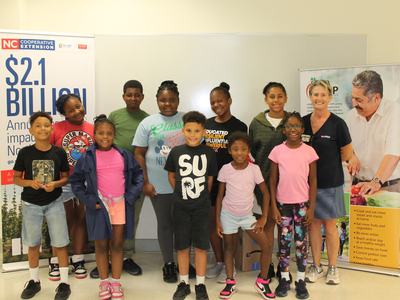 Randolph House students stand at graduation with EFNEP Agent Angie Lawrence.