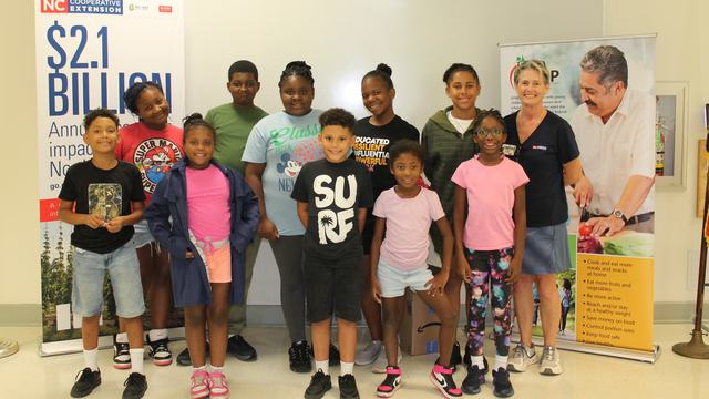 Randolph House students stand at graduation with EFNEP Agent Angie Lawrence.
