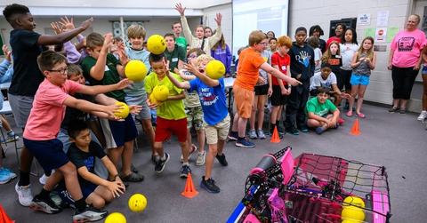 Image of youth catching basketballs thrown by robot at stem camp