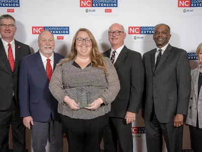 Group photo of various men and women in dress clothing at an award presentation.