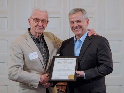 Dr. Jim Clark stands with Governor Josh Stein during his induction into the Order of the Long Leaf Pine at the governor’s mansion.
