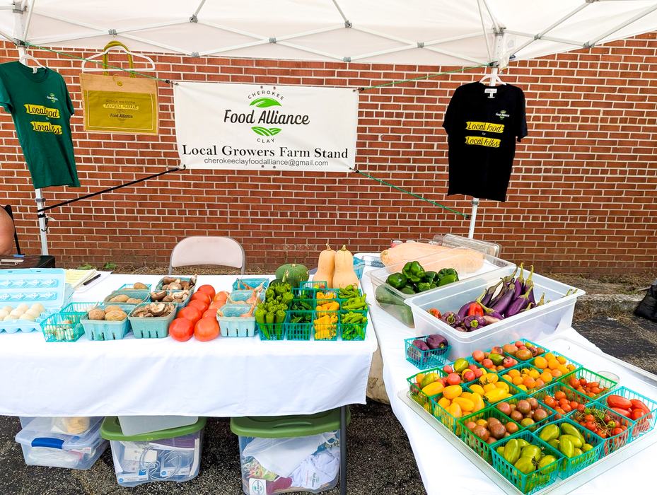 Local Grower Farmstand in Andrews, NC displays abundance of produce at a farmers market stand.