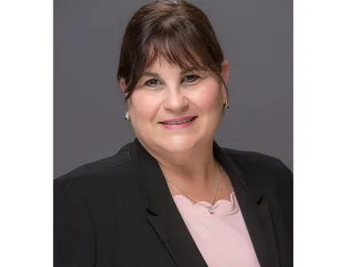 Professional headshot of Lisa Smith.  Woman wearing a pink shirt and black jacket.