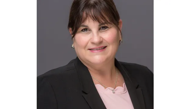 Professional headshot of Lisa Smith.  Woman wearing a pink shirt and black jacket.