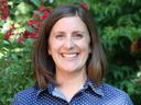 A profile photo of NC State Extension Interim Assistant Director of Youth Programs Liz Driscoll smiling, with flowering shrubbery in the background.