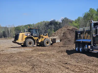 Loading Composted Mulch generated from storm debris into a dump truck