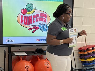 Lynnell standing in front of a screen teaching in a first grade classroom