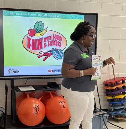 Lynnell standing in front of a screen teaching in a first grade classroom
