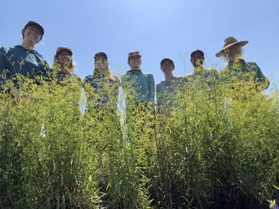A group of people standing in front of a field of flowers