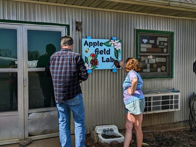 People hanging up sign on building