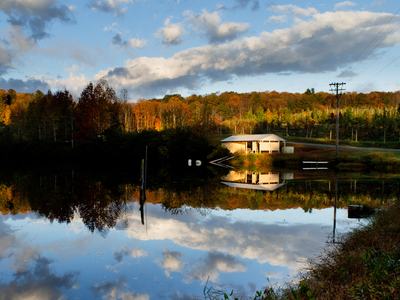 Building in autumn reflected in irrigation pond