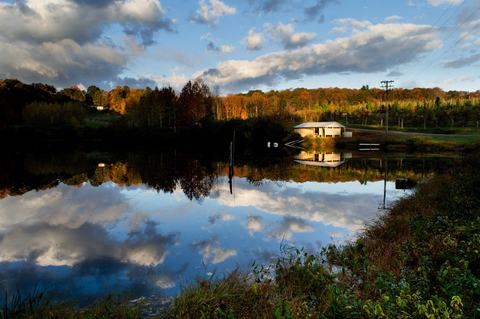 Building in autumn reflected in irrigation pond