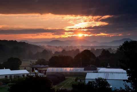Sunrise over buildings with mountains in background
