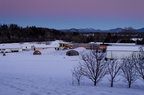 Buildings and greenhouses in snow in evening