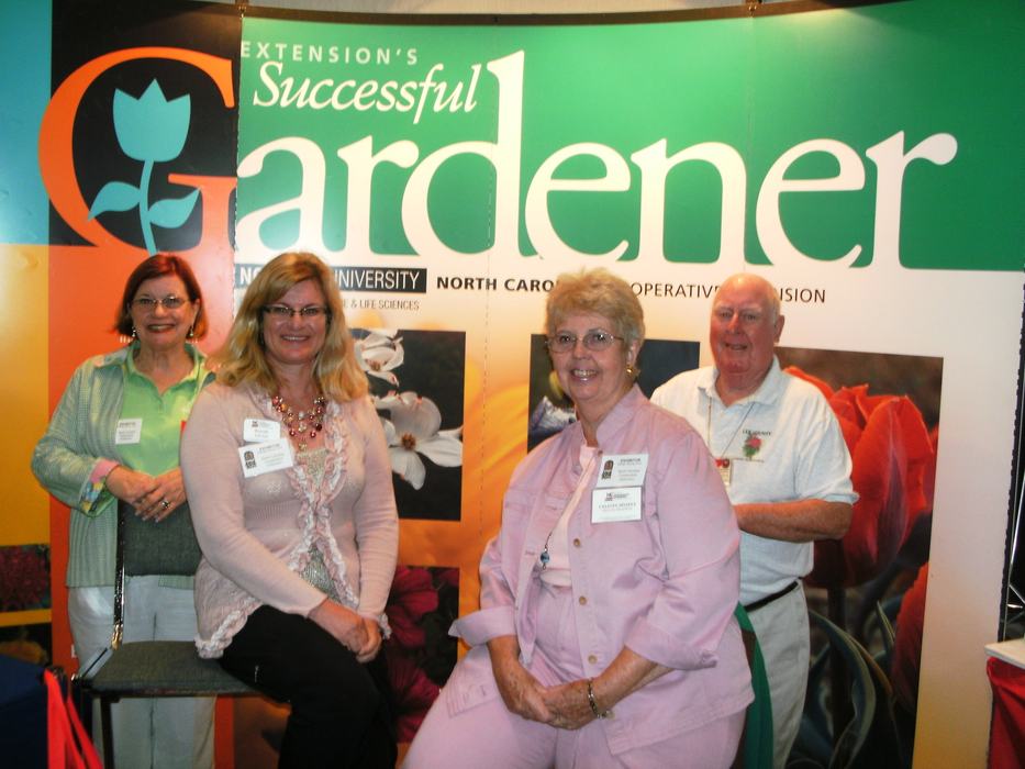 volunteers posing with educational booth at a trade show