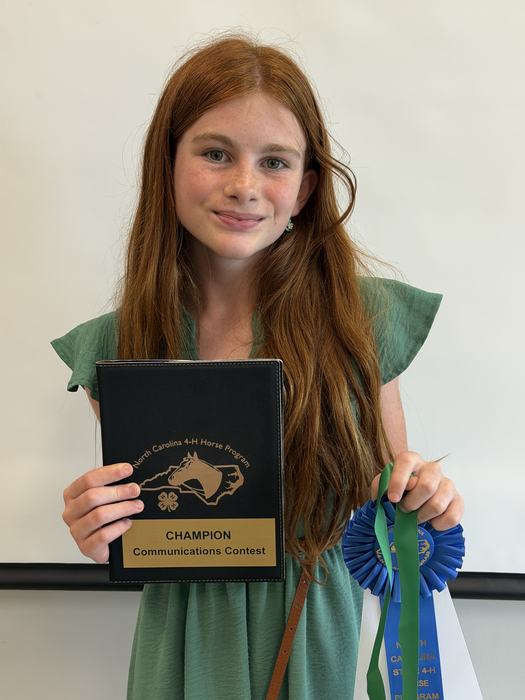Maple Kemp 11-13 Presentation Winner with her first place ribbon, medal and padfolio