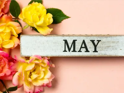 flowers next to block that reads May for decoration