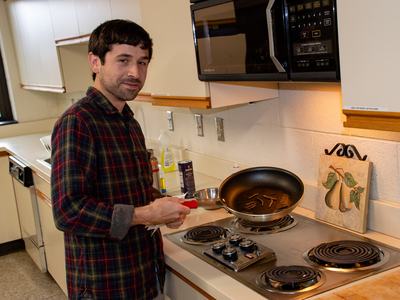 Person holding frying pan full of caterpillars