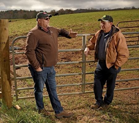 Damon Pollard in a pasture talking with a producer.