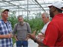 Four people seeking to begin an agricultural business tour a local greenhouse production system