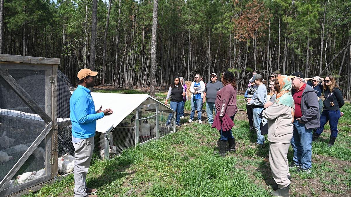 A farm owner in Durham County speaks to a group of NC Farm School students about his poultry operation