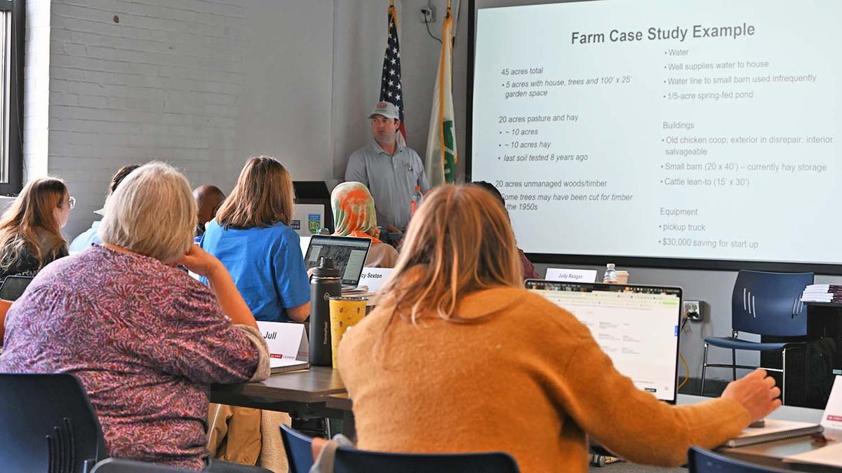 NC Farm School director Derek Washburn teaches a session inside a classroom as students look on