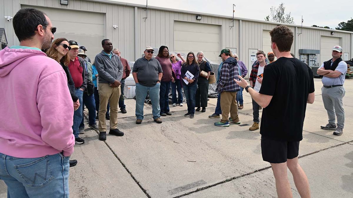 The owner of a microgreens farm in Durham talks with a group of NC Farm School students