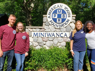 North Carolina 4-H youth stand in front of the American Youth Foundation Miniwanca sign while participating in National Leadership Conference.