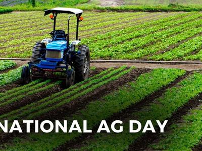 Photo of tractor in row crops. Bottom of photo captioned 'national ag day'