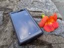 cell phone and a flower on a rock