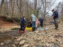 People are taking water samples in a stream.